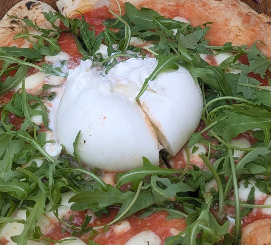 Pizza topped with burrata and rocket